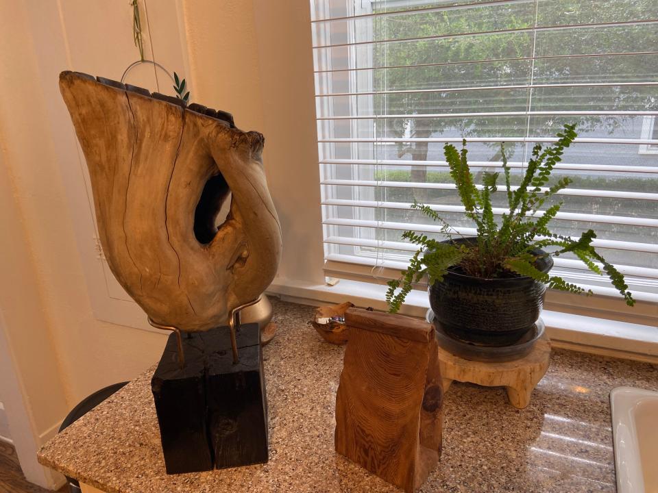 Stephen Holmes' cypress tree knee was hollowed out and darkened inside for contrast. The piece of wood shaped like a sack lunch is to commemorate St. John's Episcopal Church sack lunch program in which Holmes donates a large portion of his profits to.