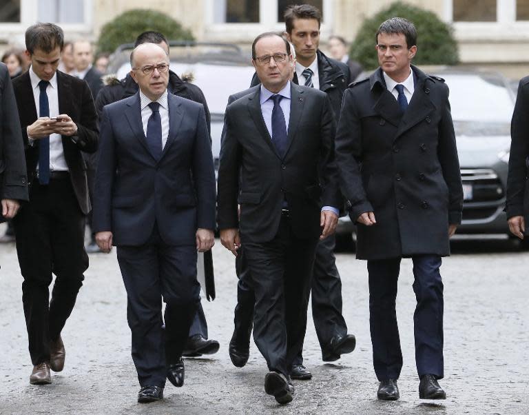 French President Francois Hollande (C) leaves the Interior Ministry in Paris with Prime Minister Manuel Valls (R) and Interior Minister Bernard Cazeneuve (L) after crisis talks