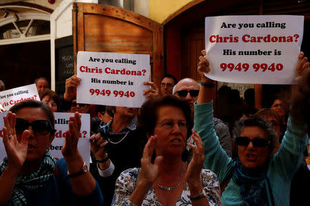 Civil society activists call on the police to question Maltese Economy Minister Chris Cardona, after some of the journalists from the Daphne Project initiative reported him as having met with one of the men accused of the murder of anti-corruption journalist Daphne Caruana Galizia, outside the police station in Valletta, Malta April 19, 2018. REUTERS/Darrin Zammit Lupi