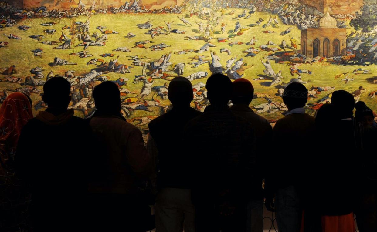 Indian visitors look at a painting depicting the Amritsar Massacre at Jallianwala Bagh. <a href="https://www.gettyimages.com/detail/news-photo/indian-visitors-look-at-a-painting-depicting-the-amritsar-news-photo/120271580?adppopup=true" rel="nofollow noopener" target="_blank" data-ylk="slk:Narinder Nanu/AFP via Getty Images);elm:context_link;itc:0;sec:content-canvas" class="link ">Narinder Nanu/AFP via Getty Images)</a>