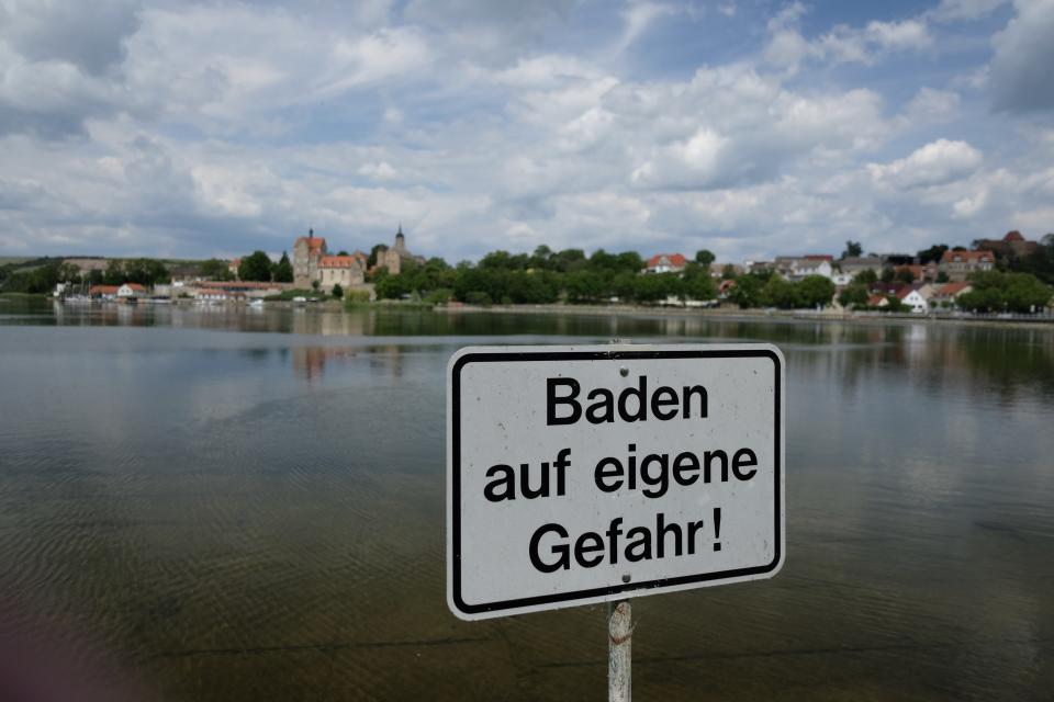 08 June 2020, Saxony-Anhalt, Seeburg: A sign with the inscription "Bathing at your own risk" stands on the shore of the sweet lake at the lake terraces Seeburg. This bathing area was criticised in the annual bathing water report. If you are looking for cooling off at German lakes, rivers and coasts this summer, you can look forward to predominantly excellent water quality. Only eight of the 2291 German bathing sites investigated failed this time in the annual evaluation because too many questionable bacteria were discovered in the water. Photo: Sebastian Willnow/dpa-Zentralbild/dpa (Photo by Sebastian Willnow/picture alliance via Getty Images)