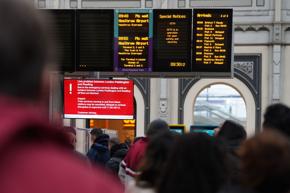 Passengers looking at information boards at Paddington station as rail services at the UK's second busiest station are suspended after a person was struck by a train (PA)