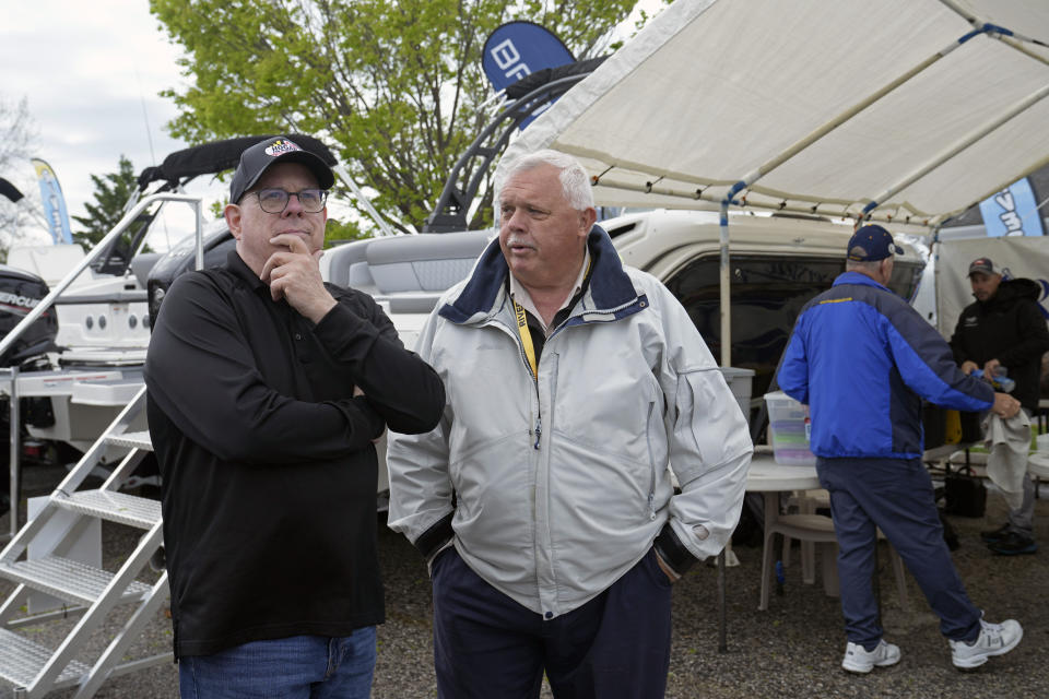 Former Maryland Gov. Larry Hogan, left, talks with Dave Baumgartner, right, the president of Riverside Marine in Essex, Md., during a visit to the Bridge Boat Show in Stevensville, Md., Friday, April 12, 2024, as Hogan campaigns for the U.S. Senate. (AP Photo/Susan Walsh)