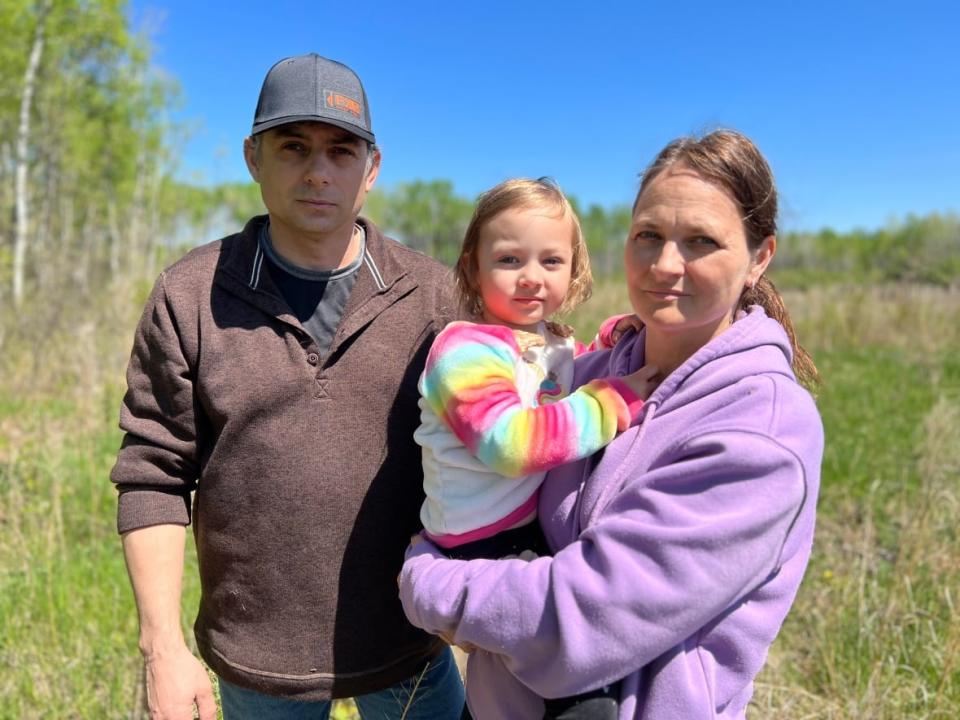 Josh and Georgina Mustard, seen with their youngest child, Callie, hope Manitoba's Clean Environment Commission does not approve Sio Silica's proposal to extract sand from below the surface of southeastern Manitoba. (Gary Solilak/CBC - image credit)