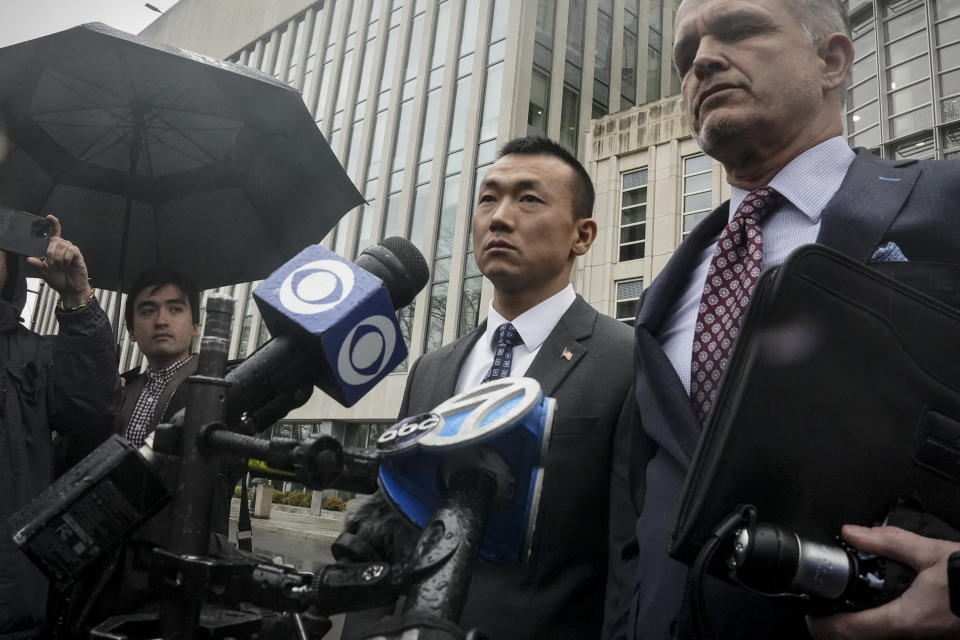NYPD officer Baimadajie Angwang, center, a naturalized U.S. citizen born in Tibet, and his attorney John Carman, right, hold a press briefing outside Brooklyn's Federal court after a judge dismissed spy charges against him, Thursday Jan. 19, 2023, in New York. Federal prosecutors dropped charges against Angwang, who authorities had initially accused of spying on independence-minded Tibetans on behalf of the Chinese consulate in New York. (AP Photo/Bebeto Matthews)