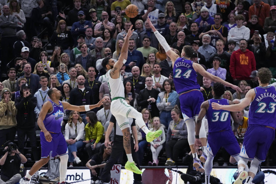 Utah Jazz center Walker Kessler (24) defends against Boston Celtics forward Jayson Tatum, center, during the second half of an NBA basketball game Saturday, March 18, 2023, in Salt Lake City. (AP Photo/Rick Bowmer)