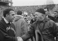FILE - In this Nov. 19, 1966, file photo, Notre Dame football coach Ara Parseghian, left, shakes hands with Michigan State coach Duffy Daugherty after their 10-10 tie in East Lansing, Mich. The game was a slog, most memorable for Irish coach Ara Parseghian playing it safe at the end without his injured starting quarterback and settling for a tie. (AP Photo/File)