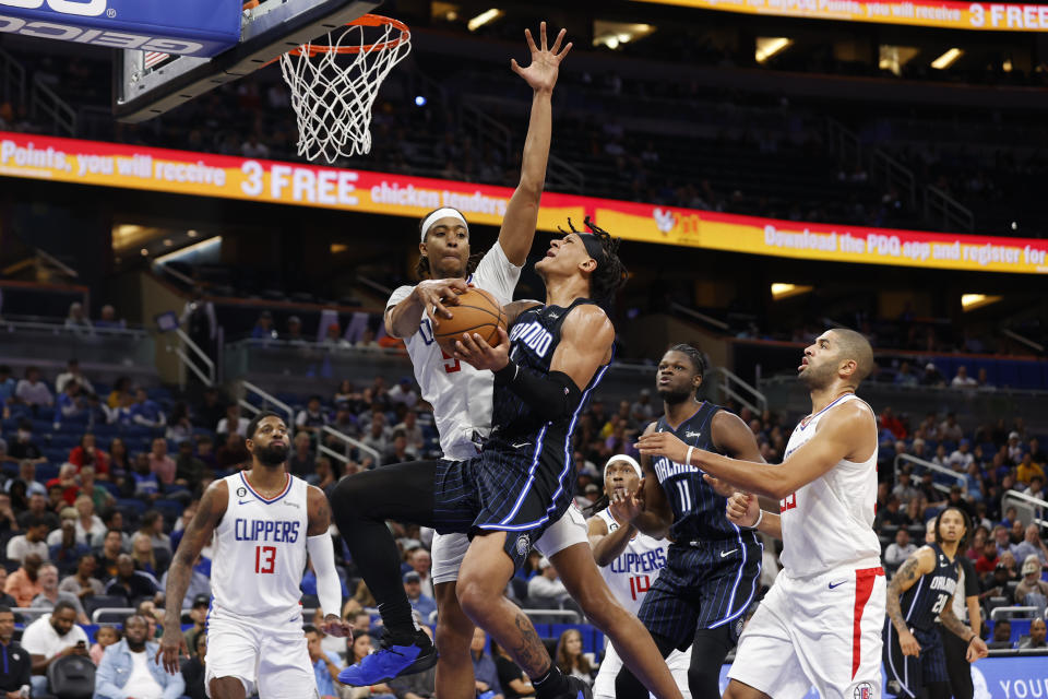 Orlando Magic forward Paolo Banchero drives to the basket under pressure from Los Angeles Clippers guard Luke Kennard during the first half of an NBA basketball game Wednesday, Dec. 7, 2022, in Orlando, Fla. (AP Photo/Scott Audette)