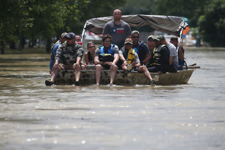 A rescue boat evacuates people from the rising water of Buffalo Bayou following tropical storm Harvey in a neighborhood west of Houston, Texas, U.S., August 30, 2017. REUTERS/Carlo Allegri
