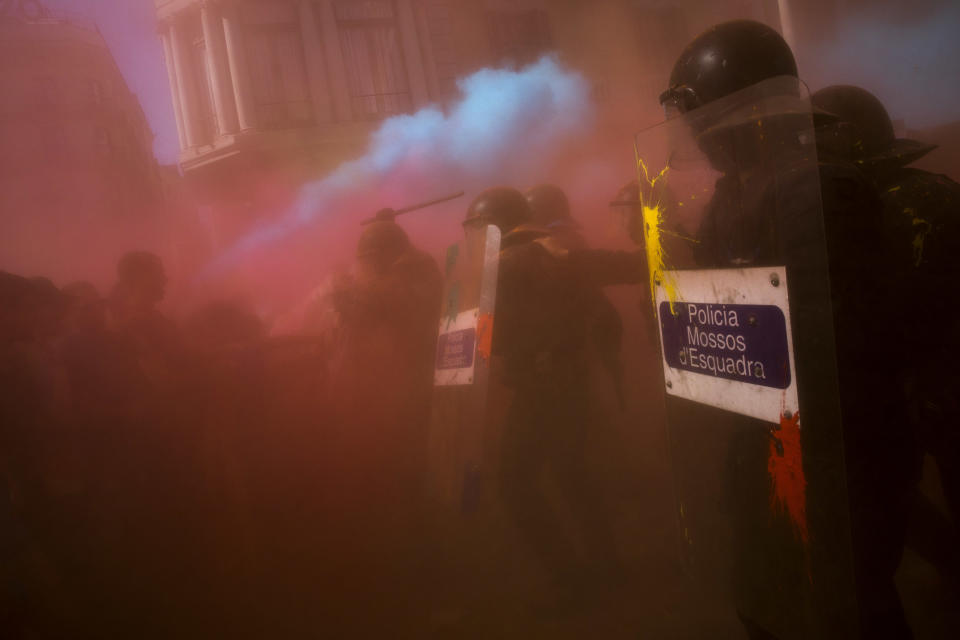 Catalan police officers clash with pro independence demonstrators on their way to meet demonstrations by member and supporters of National Police and Guardia Civil, as coloured powder is seen in the air after being thrown by protesters, in Barcelona on Saturday, Sept. 29, 2018. (AP Photo/Emilio Morenatti)