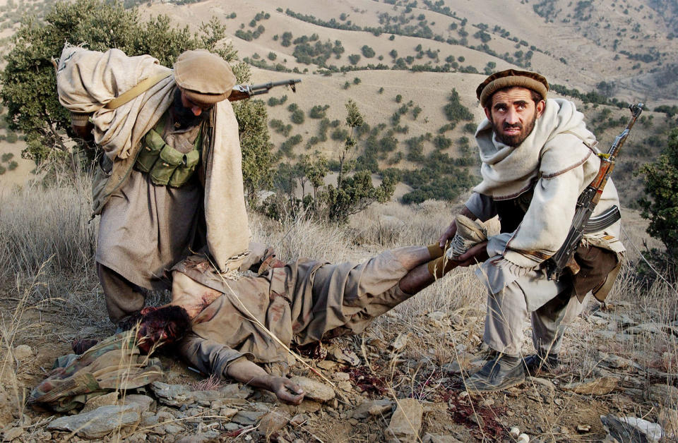 <p>Anti-Taliban soldiers carry off the body of an al Qaeda soldier they just killed in battle December 11, 2001 in the Tora Bora area of Afghanistan. Anti-Taliban forces made more gains against entrenched al Qaeda forces, prompting talks of a ceasefire and possible surrender by Osama bin Ladens terrorist organization. (Photo by Chris Hondros/Getty Images) </p>