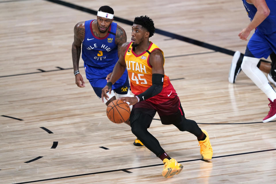 Donovan Mitchell dribbles past the Nuggets' defense. 