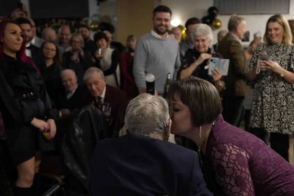 D-Day veteran Bill Gladden is kissed by his niece Kaye Thorpe as he arrives at a surprise 100th birthday party in Haverhill, England, Friday, Jan. 12, 2024. Gladden spoke to the AP on the eve of his 100th birthday, and is a veteran of the 6th Airborne Armoured Reconnaissance Regiment, part of the British 6th Airborne Division, he landed by glider on the afternoon of D-day, 6th June 1944 in Normandy. Gladden was born January. 13, 1924. (AP Photo/Alastair Grant)