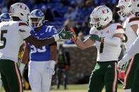 Miami wide receiver Xavier Restrepo (7) celebrates his touchdown reception with teammate Key'Shawn Smith (5) as Duke linebacker Dorian Mausi (35) looks on in the background during the first half of an NCAA college football game Saturday, Nov. 27, 2021, in Durham, N.C. (AP Photo/Chris Seward)