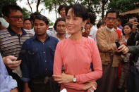 FILE - Burmese pro-democracy leader of the NLD (National League for Democracy) Aung San Suu Kyi, center, answers reporters' questions after a news conference at her residence in Rangoon, Burma on May 23, 1996. Myanmar court on Monday, Dec. 6, 2021, sentenced ousted leader Suu Kyi to 4 years for incitement and breaking virus restrictions, then later in the day state TV announced that the country's military leader reduced the sentence by two years. (AP Photo/Richard Vogel, File)