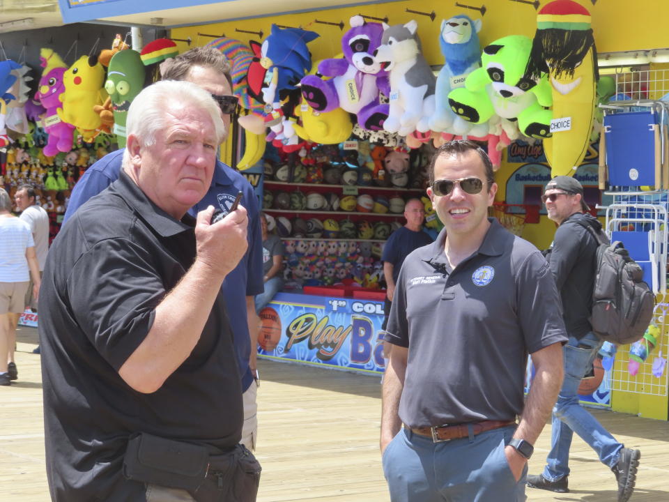 Seaside Heights Police Chief Thomas Boyd, left, speaks with New Jersey Attorney General Matthew Platkin on the boardwalk in Seaside Heights, N.J., Friday, May 31, 2024 shortly before Platkin blamed the city of Wildwood, N.J., for not assigning enough police officers to patrol its boardwalk over the Memorial Day weekend when crowds of rowdy teens and young adults overwhelmed the city's capability to respond to disturbances, forcing the boardwalk to be shut down overnight on Sunday, May 26. (AP Photo/Wayne Parry)