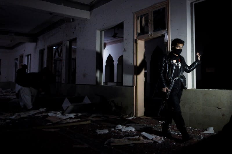 A police officer walks amid debris after a bomb blast in a mosque, in Quetta,