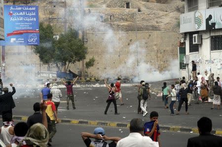 Pro-Houthi police troopers use tear gas to disperse anti-Houthi protesters in Yemen's southwestern city of Taiz March 23, 2015. REUTERS/Anees Mahyoub