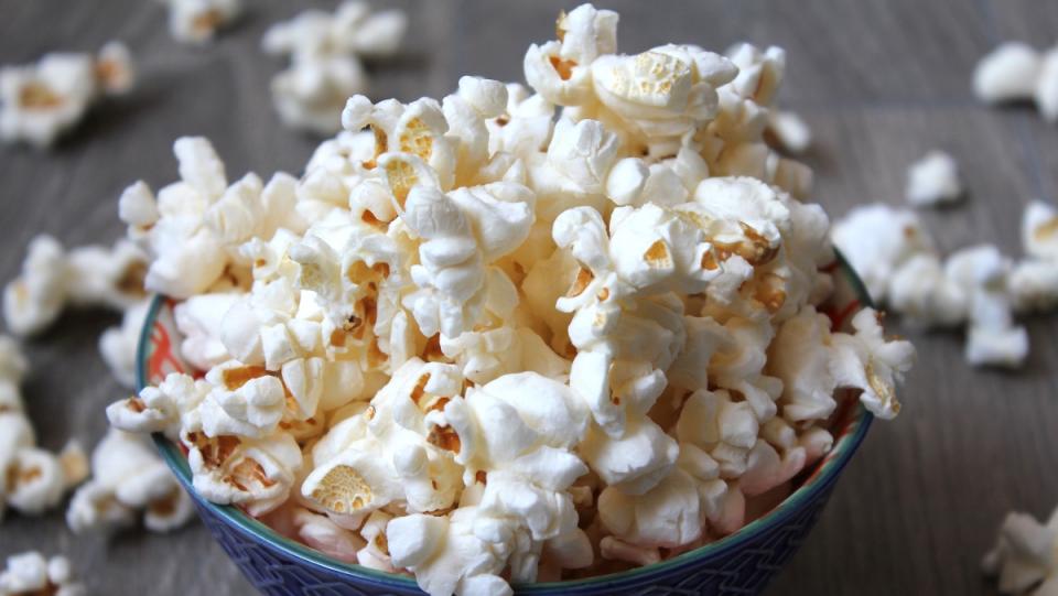 image of popcorn in a bowl with pieces scattered on table