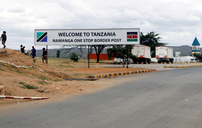 FILE PHOTO: Children walk past a signage at the border crossing point between Kenya and Tanzania in Namanga