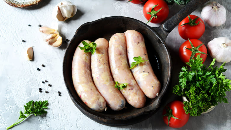 uncooked sausages in pan