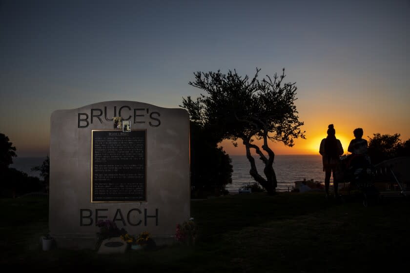 Manhattan Beach, CA - September 30: The sun sets behind a plaque memorializing a park adjacent to Bruce's Beach, the evening that California Gov. Gavin Newsom signed SB 796, authorizing the return of ocean-front land to the Bruce family, at Bruce's Beach in Manhattan Beach, CA, Thursday, Sept. 30, 2021. Some of the land making up Bruce's Beach was purchased by African American couple Willa and Charles Bruce, in 1912, establishing a resort that was open to African Americans. But by the 1920s, racial tensions grew in the beach community and the city condemned the properties. The park was renamed multiple times over the next 80 years and in 2007, was re-named for the Bruce family, responsible for trying to bring change and equality to the city. (Jay L. Clendenin / Los Angeles Times)