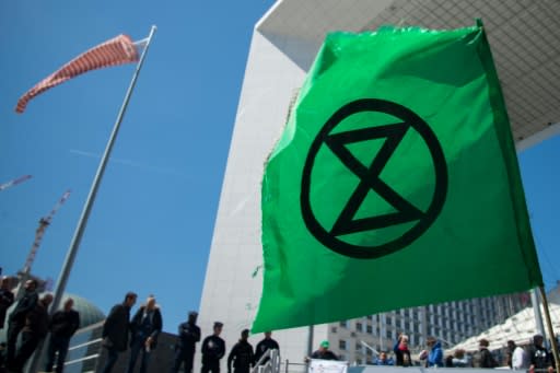 Extinction Rebellion, whose logo is seen here at a recent protest near Paris, organises acts of civil disobedience to draw attention to climate warming