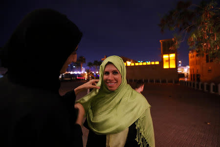 An Emirati woman volunteer helps a foreign visitor to wear a headscarf during the Muslim holy fasting month of Ramadan, at Jumeirah Mosque in Dubai, UAE May 17, 2019. REUTERS/Satish Kumar