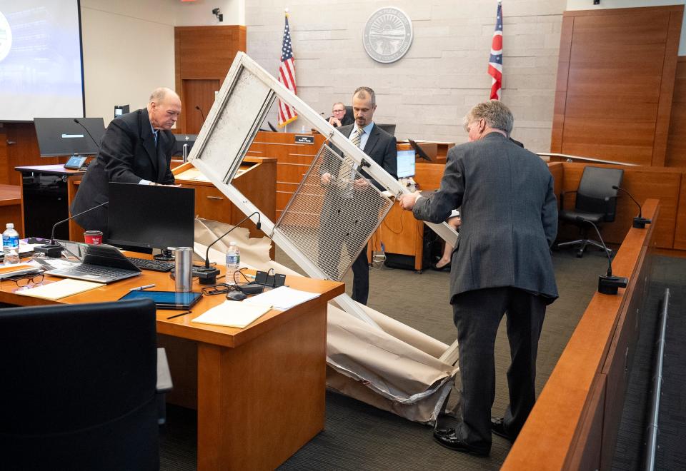 Special Prosecutor Tim Merkle, Montgomery County Assistant Prosecuting Attorney Josh Shaw and special prosecutor Gary Shroyer handle a metal door that was previously on the side door of the home of Casey Goodson Jr. to show it as evidence in the trial of Former Franklin County Sheriff's deputy Michael Jason Meade at the Franklin County Common Pleas Court.