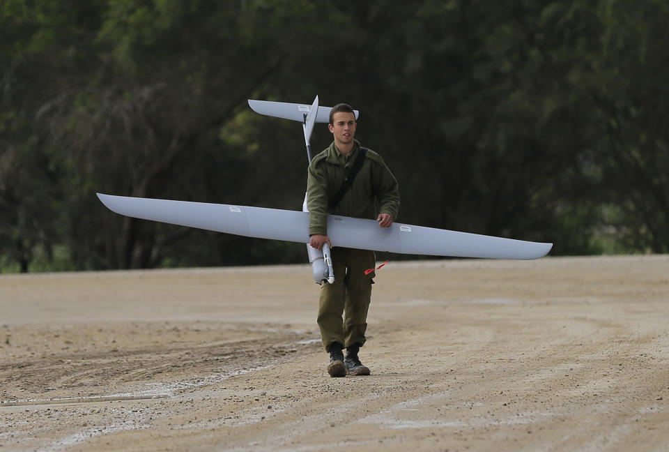 An Israeli soldier carries a drone near the Israel and Gaza border on Thursday, March 13, 2014. Gaza militants resumed rocket fire toward Israel on Thursday, striking the outskirts of two major cities a day after launching the largest barrage since an eight-day Israeli offensive in late 2012. Israel has responded with a series of airstrikes on militant targets. (AP Photo/Tsafrir Abayov)