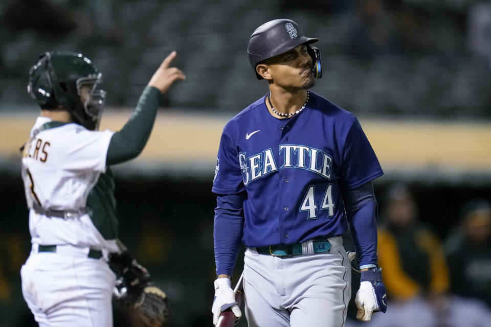 Seattle Mariners' Julio Rodríguez, right, reacts after striking out against the Oakland Athletics during the third inning of a baseball game in Oakland, Calif., Wednesday, May 3, 2023. (AP Photo/Godofredo A. Vásquez)