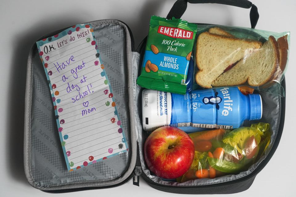 Pack a healthy lunch with nuts for protein; whole wheat bread peanut butter and cut strawberries sandwich; low-fat milk; different kinds of veggies with a yogurt ranch dip; and an apple. Don't forget the note from Mom and the ice packs.