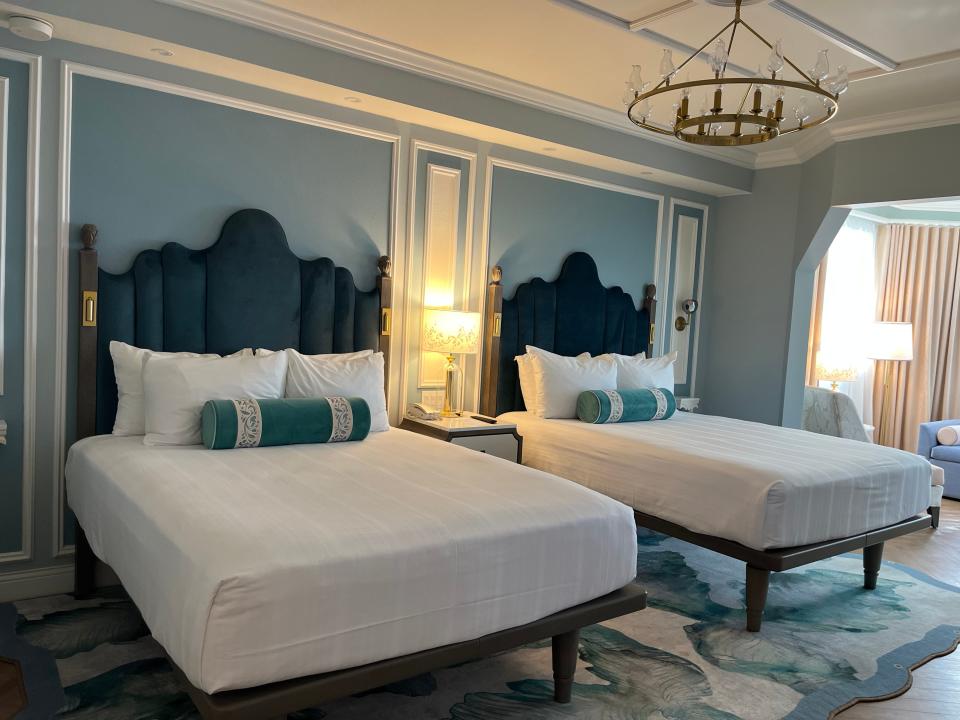 two queen beds in a room at the grand flrodian resort with blue decor details and molding on the walls