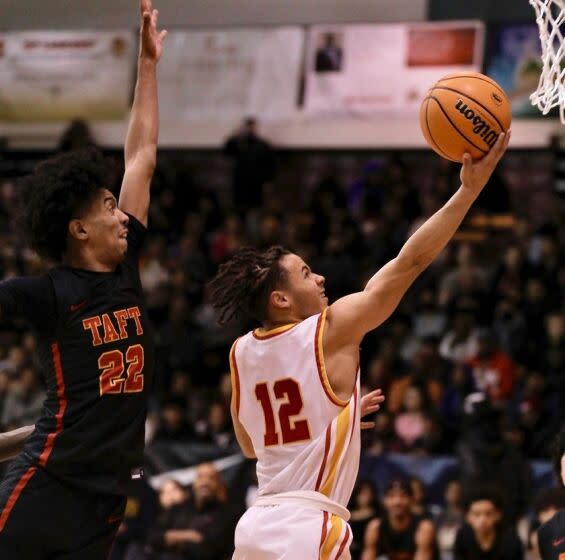 Fairfax guard David Mack drives for a layup around Taft guard Derrick Hill in the City Open Division boys basketball final.