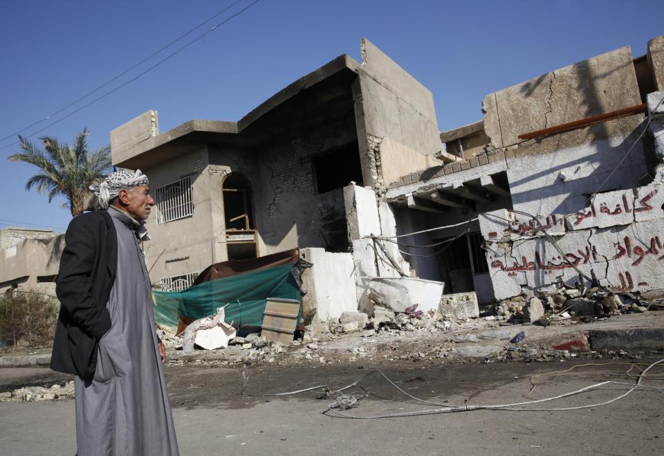 A man stands at the scene of a car bomb attack in the Risala district in Baghdad