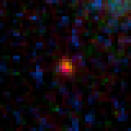 This close-up view shows the galaxy MACS0647-JD, the farthest object yet known, as it appears through a gravitational lens imaged by the Hubble Space Telescope. The galaxy is 13.3 billion light-years from Earth and formed 420 million years afte