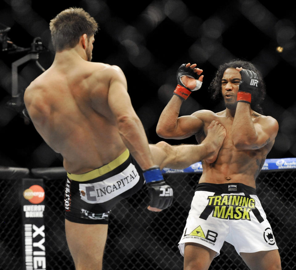 Josh Thomson, left, kicks Benson Henderson, right, during the main event of the UFC mixed martial arts event in Chicago, Saturday, Jan., 25, 2014. (AP Photo/Paul Beaty)