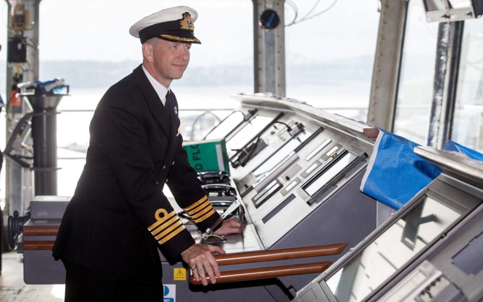 Captain Jerry Kyd, the first Commanding Officer of HMS Queen Elizabeth poses for a photograph on the bridge of the 65,000-tonne ship on May 24, 2016 - AFP