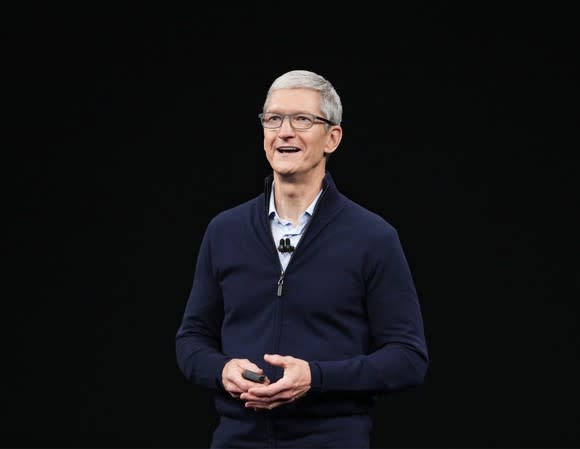 Apple CEO Tim Cook speaking in front of a black backdrop.