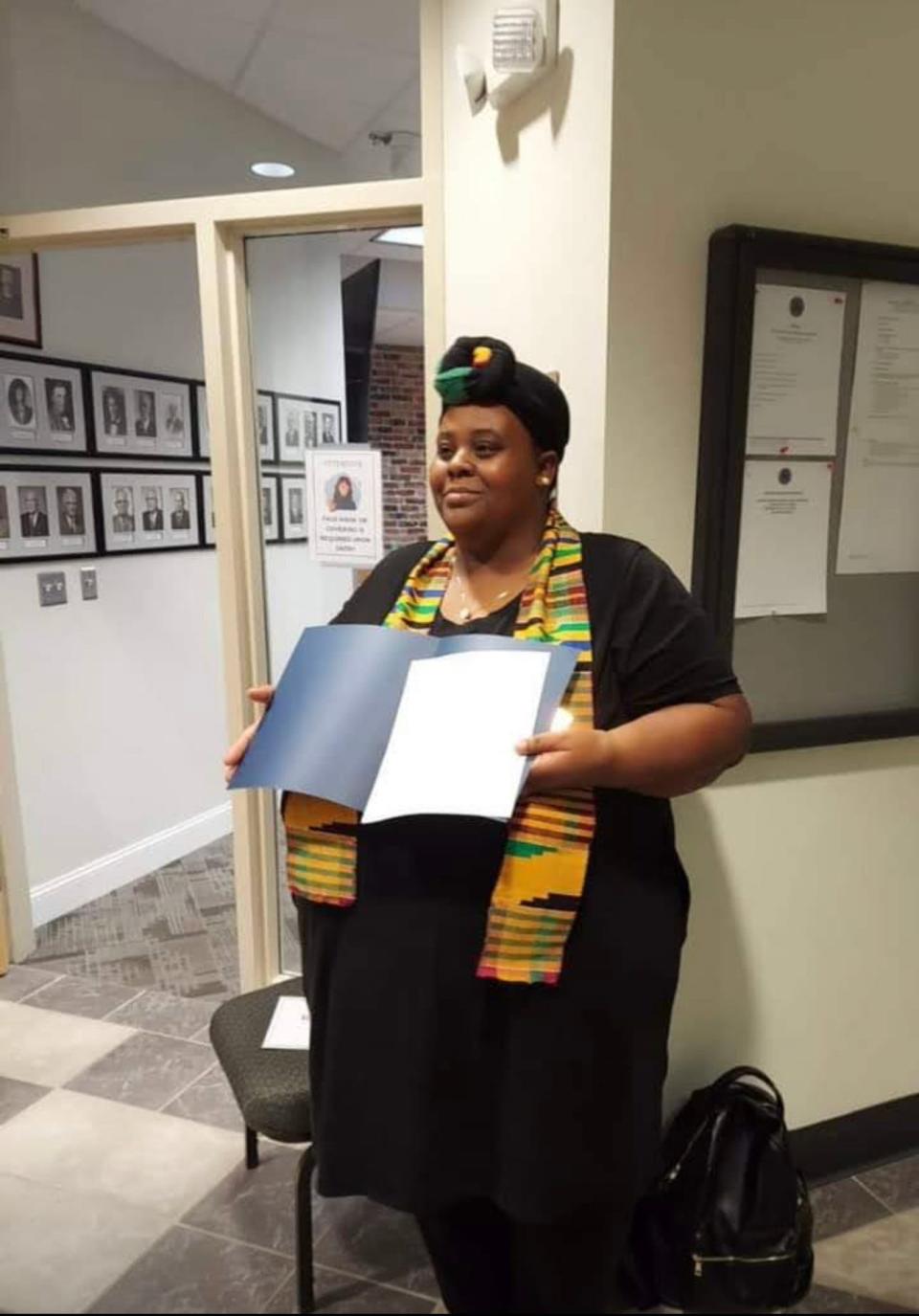 Crystal Cauley holds the first Kwanzaa Proclamation for the city of Brevard from Brevard Mayor Maureen Copelof.