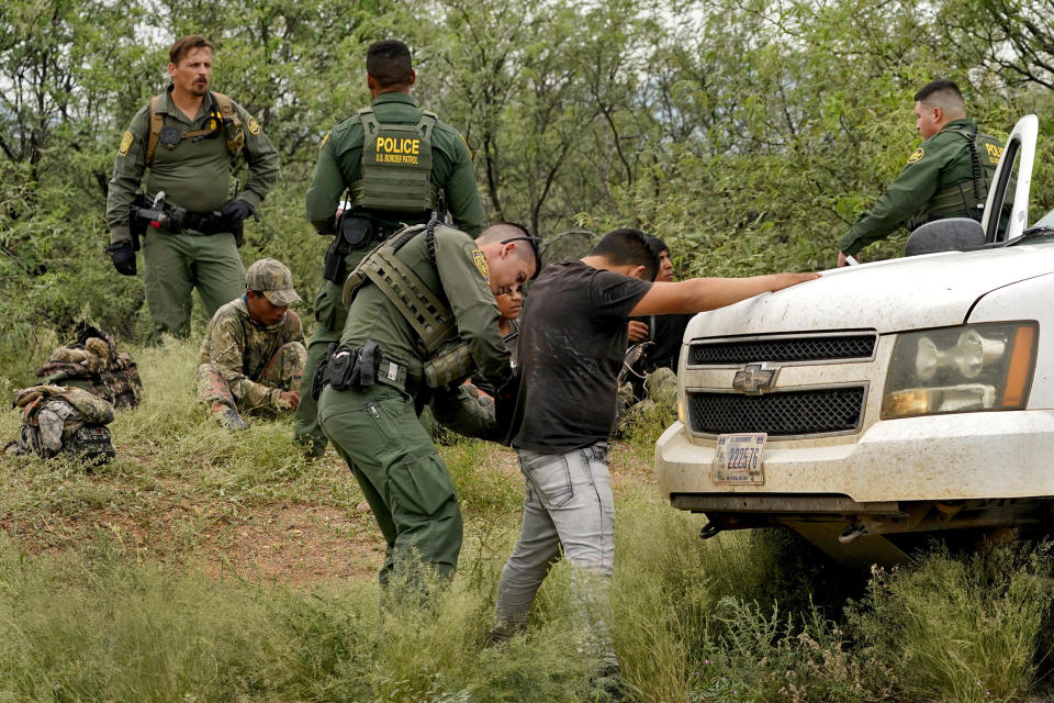 Migrants are processed after being apprehended by U.S. Border Patrol agents in the desert at the base of the Baboquivari Mountains, Thursday, Sept. 8, 2022, near Sasabe, Ariz. The desert region located in the Tucson sector just north of Mexico is one the deadliest stretches along the international border with rugged desert mountains, uneven topography, washes and triple-digit temperatures in the summer months. Border Patrol agents performed 3,000 rescues in the sector in the past 12 months. (AP Photo/Matt York)