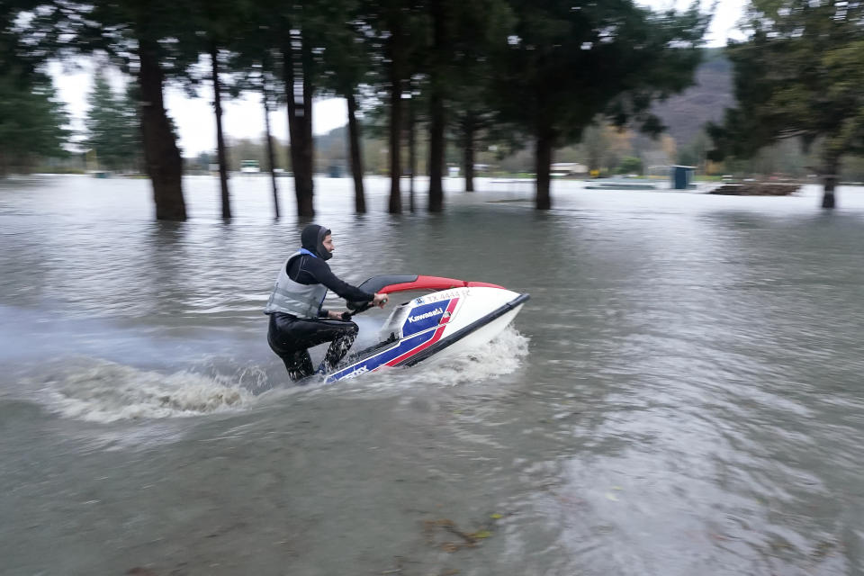 T.J. Snody takes off on a personal watercraft into a park flooded by water from the Skagit River, Monday, Nov. 15, 2021, in Sedro-Woolley, Wash. (AP Photo/Elaine Thompson)