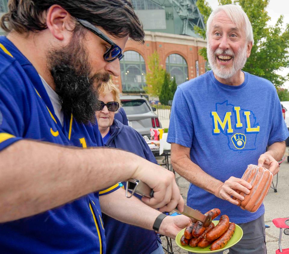 From left to right, Benjamin, Barb and Alan grill some hotdogs Thursday, Sept. 28, 2023, at American Family Field in Milwaukee. This is their first time tailgating this season, they are season ticket holders. They look forward to tailgating more next season. "Great people. This is Wisconsin," Alan said. "It is the perfect venue for tailgating. It's the perfect aroma and a lot warmer out here compared to Lambeau Field," Barb expressed.