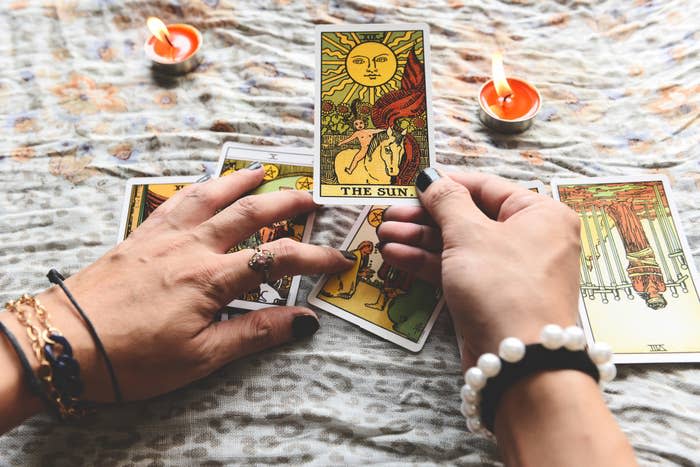 hands holding out tarot cards