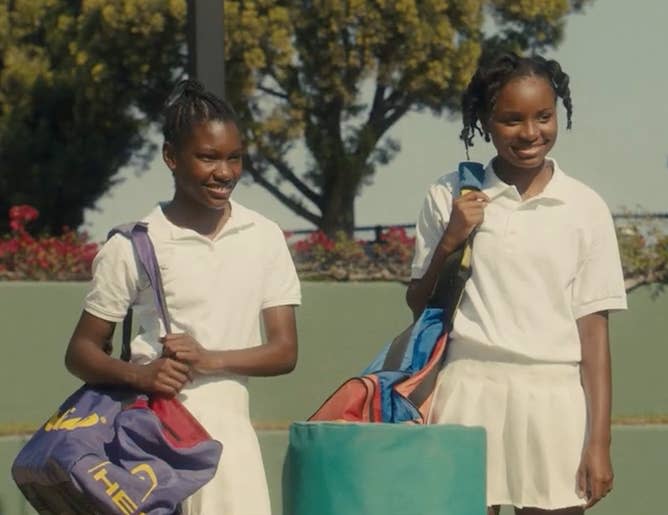 Demi Singleton as Serena Williams and Saniyya Sidney as Venus Williams, dressed in tennis clothes on a tennis court