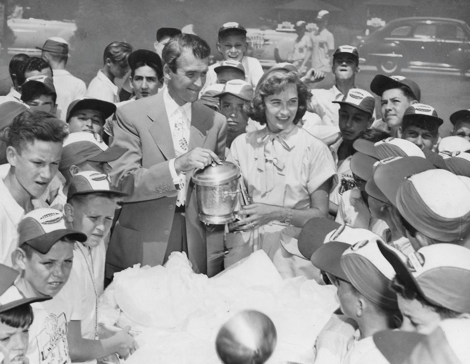 Hollywood star Jimmy Stewart and his newlywed bride, Gloria, cut their honeymoon short in August 1949 so they could attend the All-American Soap Box Derby in Akron. Here they are holding a wedding present they received at Derbytown. Stewart visited the Soap Box Derby six times over the years.