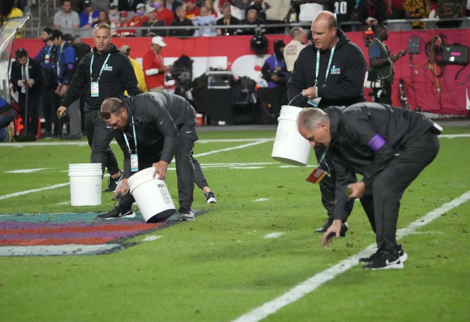 Workers remove loose grass at halftime during Super Bowl LVII between the Kansas City Chiefs and the Philadelphia Eagles at State Farm Stadium in Glendale on Feb. 12, 2023.