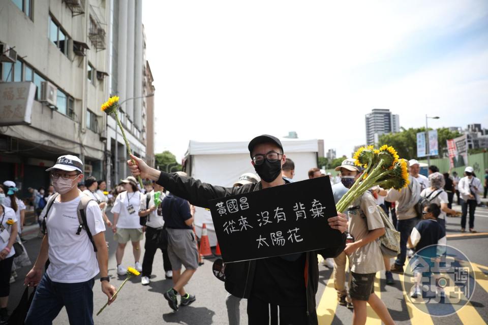 民眾手拿太陽花，以及手板，稱黃國昌沒有背棄太陽花。