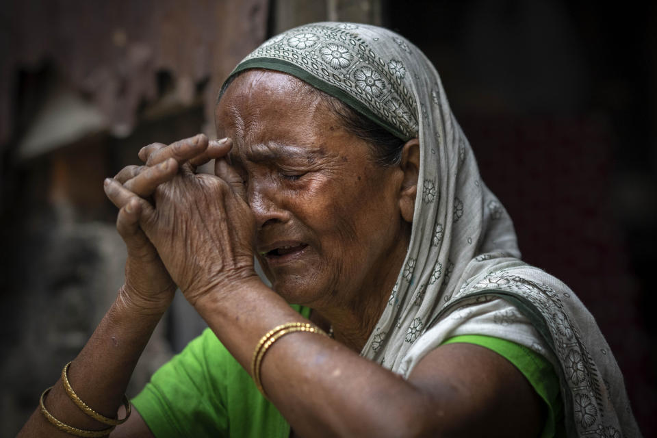 Subur Banoo, 60, wife of late Faizul Ali, cries as she narrates her story sitting outside her house in Bahari, north eastern Assam state, India, April 16, 2023. Ali was sent to a detention center after being declared a “foreigner” in late 2015, and was released on bail in 2019. He died in March, leaving behind his wife, a mentally ill son, two daughter-in-laws and their children. They all live in a single room house made of corrugated tin in this Muslim majority village. All have been declared “foreigners.” (AP Photo/Anupam Nath)