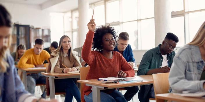 high school student raising hand in class